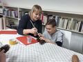 4. Uczeń z nauczycielką malujący szyszkę