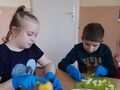 2. Dziewczynka i chłopiec obieraja i kroją jabłka