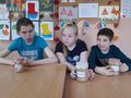7. Dziewczynka i chłopcy prezentuja swoje dżemy jabłkowe