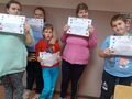 9 Grupa uczniów stoi i trzyma w rękach dyplomyjpg