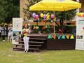 Konferansjerka Patrycja prowadząca festyn integracyjny stoi przy udekorowanej balonami scenie