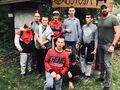 Grupa chłopców razem z opiekunami pozuje do zdjęcia przed Ostoją Milicką