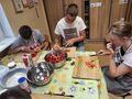 4. Liwia Adam i Karol kroją truskawki w plasterki