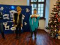 uczniwie wcialają się w rolę Maryji z dzieciątkiem i józefa stoją obok choinki