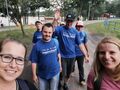 Harcerze z druhnami spacerują po ścieżce w tle widać drzewa i jezioro