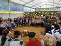 Harcerze jedenastu drużyn siedzą w kole w szkolnym namiocie od hipoterapii