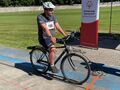 3. Uczeń siedzi na rowerze w tle boisko do piłki nożnej 