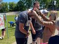 6. Uczniowie stoją na podium. Jeden z nich ma zawieszany medal pochyla głowę 