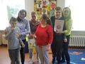 4. Grupa uczniów wraz z nauczycielami stoi w klasie trzymają nagrody i dyplomy