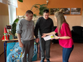 Nauczycielka wręcza nagrodę uczniom 