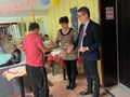 Kobieta wręcza uczniowi dyplom. Obok Burmistrz Zdun. W ręce trzyma medal. W tle kolorowe balony tor do gry