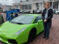 Uczeń pozujący przy zielonym Lamborghini na targach mnotoryzacyjnych w Ponaniu