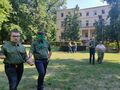 Drugny i druhowie chodzą parami po parku. Jedna osoba z każdej pary ma zasłonięte oczychustą harcerską druga osoba ją prowadzi 