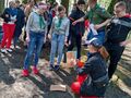 Harcerze razem z nauczycielem rozwiązują zadania. Znajdują się w szkolnym parku 