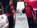 Uczeń wraz z trenerem przy płonącym zniczu olimpijskim