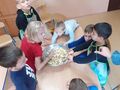 1. Uczniowie najmłodszych klas mieszają sałatkę owocową 