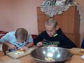 3. Dwoje uczniów kroi owoce na sałatkę 