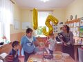 5 Nauczycielka gra na gitarze i śpiewa Sto Lat a dzieci stoją przy stole