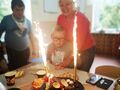 7 Chłopiec z opiekunką przy stole na którym jest tort z zapalonymi świeczkami i racami