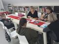 1 wychowankowie wraz z nauczycielką siedzą przy stole w bibliotece