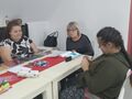 2 wychowankowie wraz z panią bibliotekarką siedzą przy stole