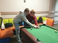 2 Nauczyciel uczy chłopca jak trzymac kij do bilarda