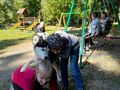 8 Dziewczynka i chłopiec bawią się z psem w tle siedzą pozostałe dzieci