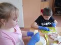 1 Dziewczynka ściera ser żółty a chłopiec kroi szynkę