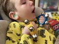 Uczeń siedzi na pufie z granulatu w prawej ręce trzyma żółte dzwoneczki a w lewej niebieskiejpg