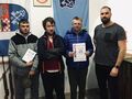 Drużyna SOW Konarzew rywalizująca w zawodach grupowych wraz z opiekunem na tle herbów miasta i powiatu