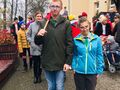 Uczniowie wraz z nauczycielami stoją przed szkołą i przygotowują się do pochodu przez miejscowość Konarzew z przodu uczeń trzyma flagę Polski