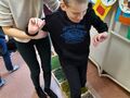1. Nauczyciel pomaga uczniowi pokonać ścieżkę sensoryczną. 