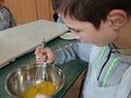 Uczeń miesza składniki potrzebne do wyrobienia ciasta