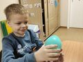 6. Nadmuchany balon chłopiec siedzi przy stole i trzyma balon