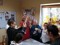 2. klasa II III PP i kl. VII VIII uczta dzieci stoją przy stole i podnoszą kubki do góry