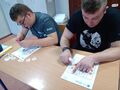 Dwaj uczniowie znajdują się w klasie siedzą przy ławce wykonują zadanie na karcie pracy 