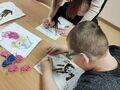 3. wykonywanie laurki przy stole przez uczniów nauczycielka pomaga