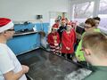 Chłopcy i dziewczynki oglądają maszyny pan demonstrujejpg