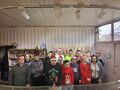 grupa uczniów wraz z nauczycielami stoją w fabryce cukierków