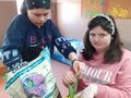 Uczennica sadzi cebulkę tulipana i obsypuje ziemią