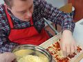 uczeń posypuje przygotowane kawałki pizzerki startym serem