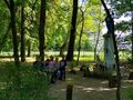 4. uczniowie razem z nauczycielem siedzą na ławce przy figurze Matki Bożej