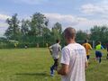 Uczestnicy meczu biegną w kółko, w trakcie rozgrzewki przed meczem