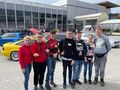 Grupa uczniów stoi z nauczycielka na placu targów notoryzacyjnych