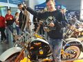 Krystian stoi przy motocyklu Harley Davidson