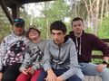 wychowankowie wraz z opiekunem siedzą na lawce na platformie widokowej