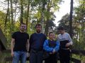 trzech chłopców wraz z nauczycielem stoją na platformie widokowej i patrzą w obiektyw do zdjęcia