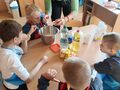 1. Uczniowie przy wsparciu nauczyciela wbijają jajka do miski 
