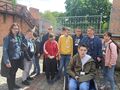 5.uczniowie i nauczyciele razem z biskupem stoją na zewnątrz przy sanktuarium św. Józefa w Kaliszu