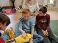 uczeń dotyka rękawicę sensoryczną obok drugi uczeń, oboje siedzą na materacu